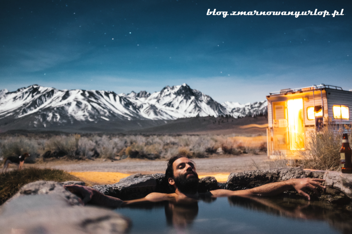 mężczyzna relaksujący się w źródełku na tle gór ilustracja do tekstu wakacje z biurem podróży
